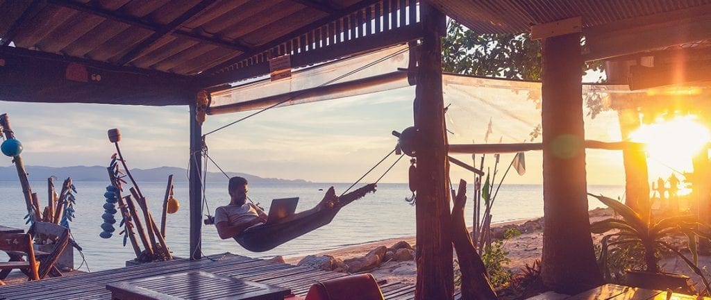 Digital nomad working on a hammock