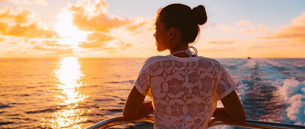 young girl enjoying the sunset from a cruise ship deck