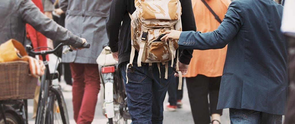 Bump and grab scam technique. Pickpocket taking a wallet out of a backpack.