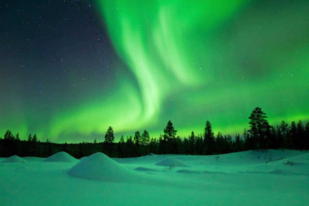 Aurora borealis over snowy winter landscape, Finnish Lapland